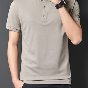 May include: A light gray short-sleeved polo shirt with a button-up collar.