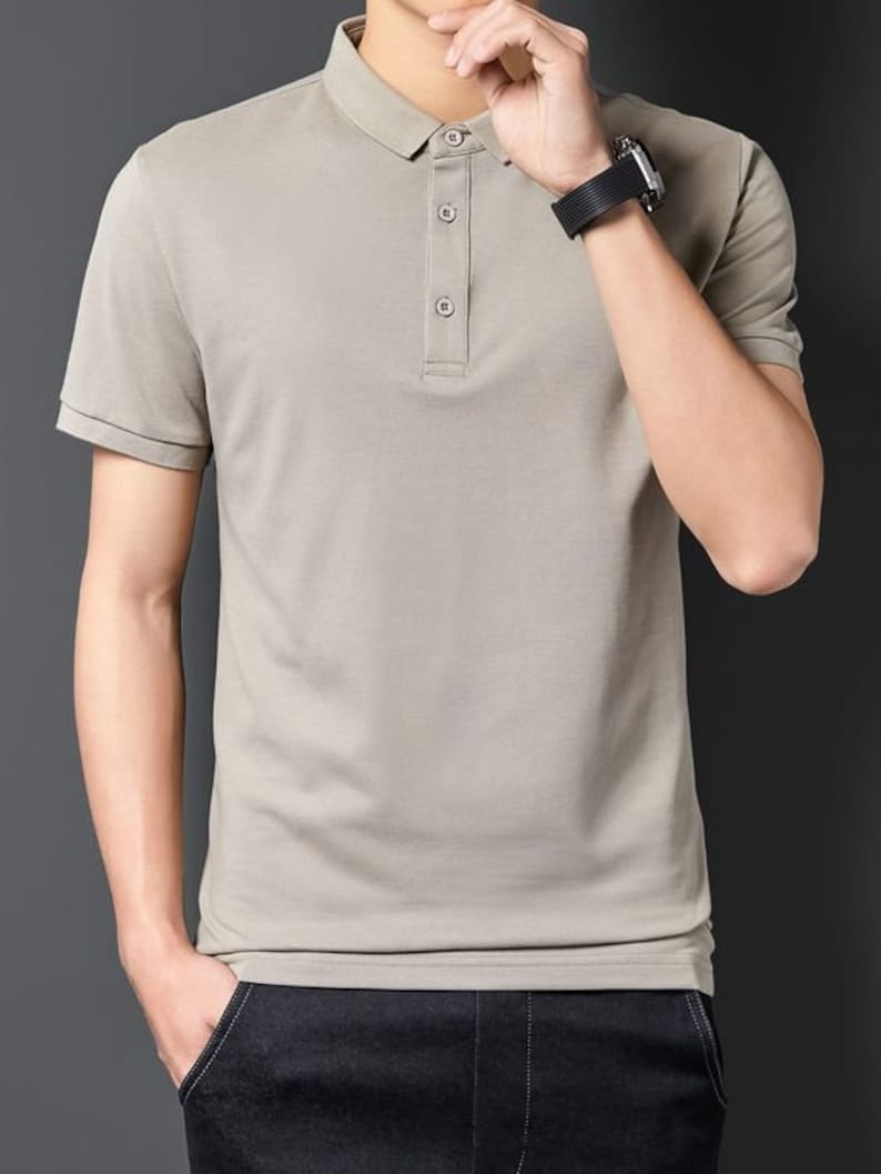 May include: A light gray short-sleeved polo shirt with a button-up collar.