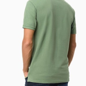 May include: A green short-sleeved polo shirt with a collared neckline.