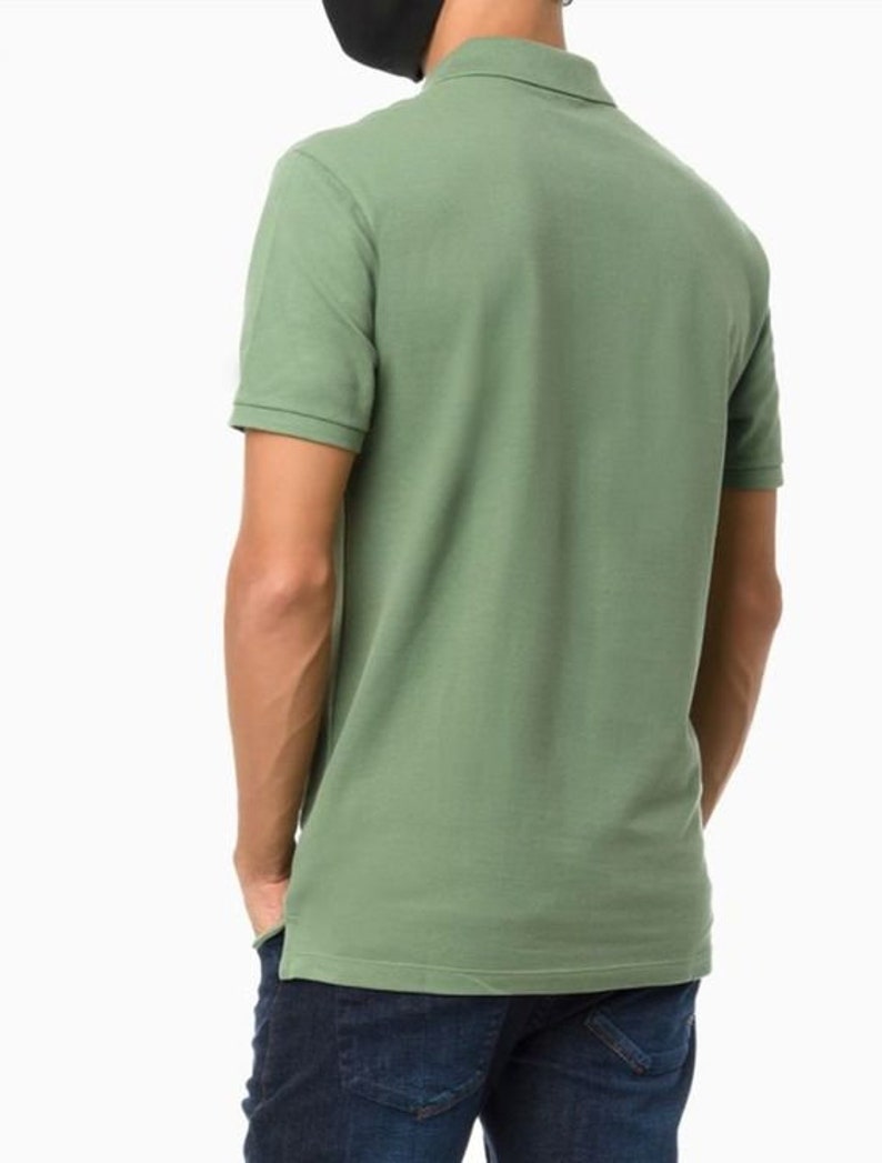 May include: A green short-sleeved polo shirt with a collared neckline.
