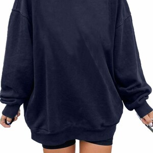 Pu&ograve; includere: Una felpa oversize blu navy con maniche lunghe e scollo rotondo.