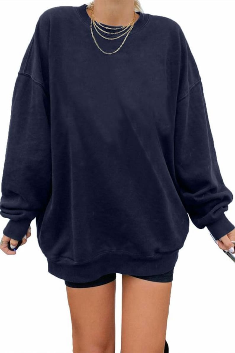 Pu&ograve; includere: Una felpa oversize blu navy con maniche lunghe e scollo rotondo.