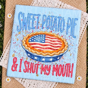Könnte beinhalten: Ein rechteckiges Schild mit hellblauem Hintergrund und einer Torte mit amerikanischem Flaggendesign auf der Kruste. Der Text SWEET POTATO PIE steht oben und & I SHUT MY MOUTH unten in roten Buchstaben, umgeben von bunten Farbspritzern.