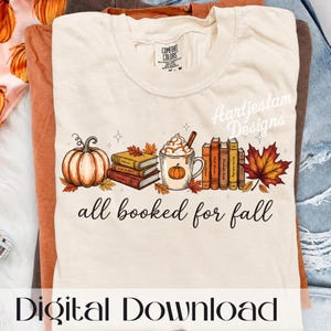 Könnte beinhalten: Ein cremefarbenes T-Shirt mit einer Grafik aus einem Kürbis, einem Bücherstapel, einer Tasse mit Schlagsahne und einem Ahornblatt. Der Text "all booked for fall" ist in schwarzer Schreibschrift gedruckt. Das Shirt hat ein Comfort Colors Etikett am Hals.