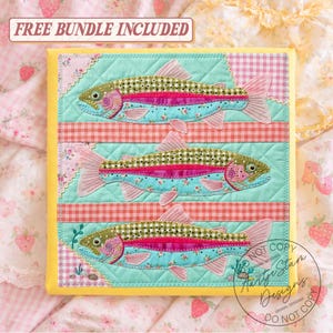 May include: A quilted wall hanging featuring three colorful fish appliqués. The fish have teal bodies with floral patterns, pink fins, and a pink and green striped pattern. The background is light blue with pink and red gingham stripes. The text "FREE BUNDLE INCLUDED" is at the top.