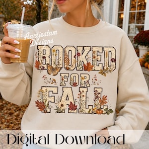 Könnte beinhalten: Ein beigefarbenes Sweatshirt mit Rundhalsausschnitt und dem Schriftzug "BOOKED FOR FALL" in Blockbuchstaben. Die Buchstaben sind mit einem Muster aus alten Buchseiten, Herbstblättern, Wildblumen, einem Schmetterling und einem Kürbis gefüllt.