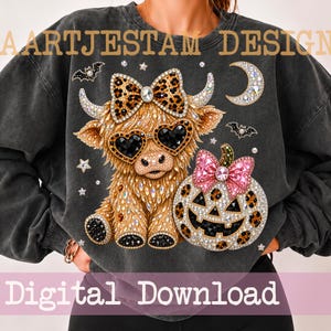 Könnte beinhalten: Ein anthrazitfarbenes Sweatshirt mit einer Grafik eines Hochlandrindes, das eine herzförmige Sonnenbrille und eine Leoparden-Schleife trägt, neben einem Leoparden-Kürbis mit rosa Schleife. Das Design zeigt Fledermäuse, Sterne und eine Mondsichel.