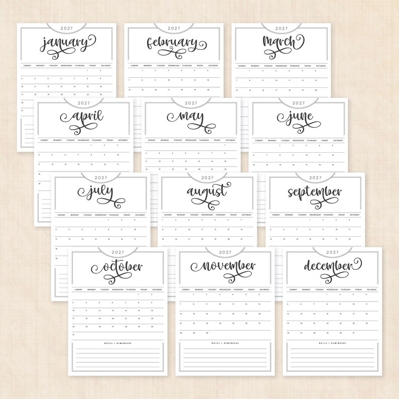 May include: A 2027 wall calendar set featuring twelve individual monthly pages. Each page displays the month name in a black cursive script, the year 2027, a grid for days of the week, and a lined section at the bottom for notes and reminders.