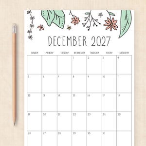 Puede incluir: Una p&aacute;gina de calendario mensual para diciembre de 2027 con una cuadr&iacute;cula y una ilustraci&oacute;n floral en la parte superior con flores rosas y hojas verdes. El calendario incluye el texto DECEMBER 2027 y los d&iacute;as. Un l&aacute;piz de madera est&aacute; colocado verticalmente.