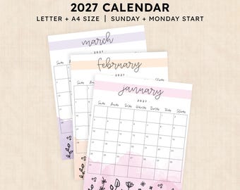 May include: A printable 2027 calendar set featuring January, February, and March pages. Each page displays a grid, month name in cursive, and floral line art at the bottom with soft watercolor accents in pink, peach, and purple hues.
