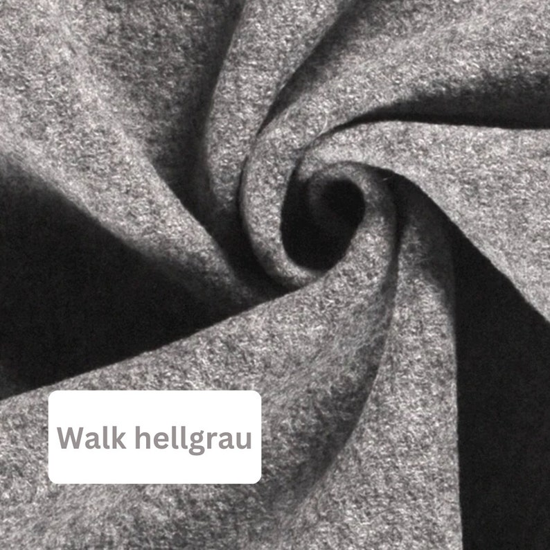 May include: Close-up of a light gray fabric with a soft, textured surface. The fabric is folded and twisted, creating a swirling pattern.
