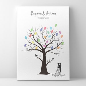 Könnte beinhalten: Ein weißer Leinwanddruck mit einer schwarzen Silhouette eines Baumes mit bunten Fingerabdrücken auf den Ästen. Der Text "Benjamin & Melanie" und "22. Januar 2023" befindet sich oben auf dem Druck. Eine Silhouette von Braut und Bräutigam befindet sich unten auf dem Druck.