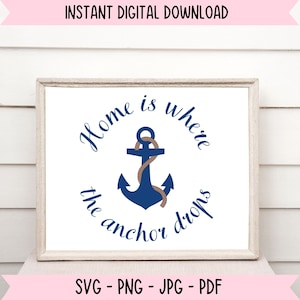 Puede incluir: Una impresión enmarcada en blanco con el texto "Home is where the anchor drops" en un gráfico de ancla azul marino y marrón.