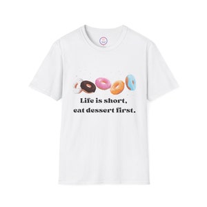 May include: White t-shirt with a graphic of five colorful donuts and the text "Life is short, eat dessert first."