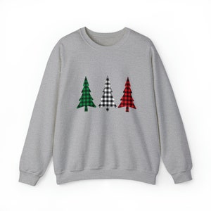 May include: A heather gray sweatshirt featuring three Christmas tree designs. The trees are green, black and white checkered, and red, each with a solid green or red trunk. The sweatshirt has a crew neck and long sleeves.