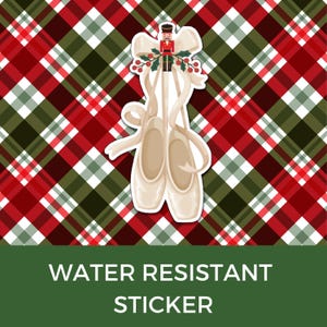 May include: A water-resistant sticker featuring a pair of ballet pointe shoes with a decorative bow, holly, and a toy soldier. The background is a red, green, and white plaid pattern. The text "WATER RESISTANT STICKER" is at the bottom.
