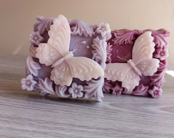 May include: Two decorative soap bars with a butterfly design. The soap bars are purple and lavender with white butterflies.
