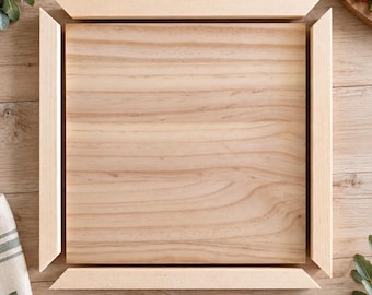 Puede incluir: Una tabla de madera de color claro de forma cuadrada situada en el centro, rodeada por cuatro piezas de marco de madera separadas y sueltas con bordes en inglete. La madera presenta un patrón de veta natural con vetas marrones claras.