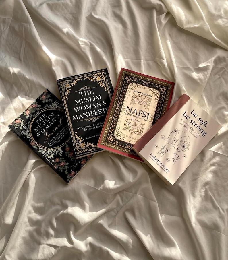 May include: Four books on a white bedspread. The books are titled "The Muslim Woman's Journal", "The Muslim Woman's Manifesto", "Nafsi", and "Be Soft, Be Strong".