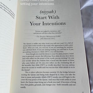 May include: Open book with text: "Always start with your setting your intentions" and "Start With Your Intentions." The text is in black on a cream-colored page. The book is open on a white surface.