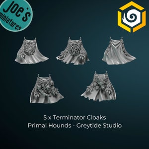 May include: Five grey plastic Terminator Cloaks for miniature figures. The cloaks have various details, including fur, feathers, and beads. The text "5 x Terminator Cloaks Primal Hounds - Greytide Studio" is printed below the cloaks.