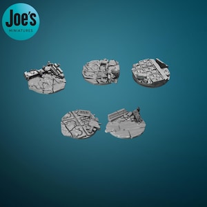 May include: Five grey miniature bases with a textured, ruined city design. Each base is round and features detailed debris, rubble, and architectural elements. The bases are designed for tabletop gaming and miniature figures. The Joe's Miniatures logo is in the upper left.