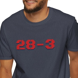 May include: A navy blue t-shirt with a red and blue graphic that says "28-3".