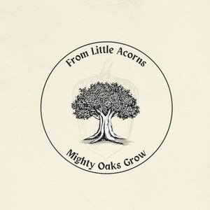 May include: A white t-shirt with a black and white illustration of a tree growing from an acorn. The text "From Little Acorns Mighty Oaks Grow" is written in a circle around the tree.