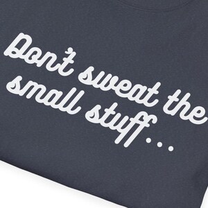 May include: A dark blue t-shirt with white text that reads "Don't sweat the small stuff..."