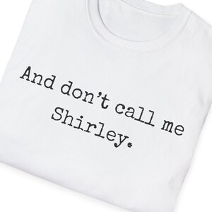 May include: White t-shirt with the text "And don't call me Shirley."