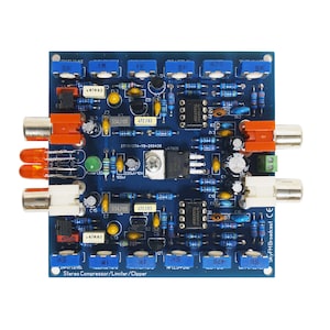 Peut inclure: Une carte de circuit imprimé bleue avec divers composants électroniques, notamment des résistances, des condensateurs et des circuits intégrés. La carte porte une étiquette indiquant "Stereo Compressor/Limiter/Clipper" et "SkyFM Broadcast CE".