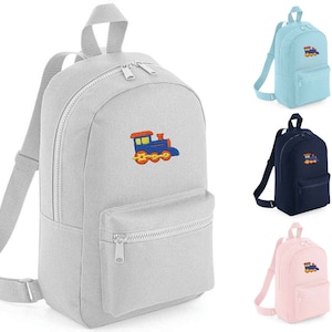 May include: A grey, blue and orange train embroidered on a grey canvas backpack. The backpack has two zipped compartments and adjustable straps.