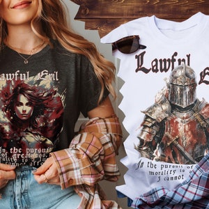 Può includere: Due t-shirt con il testo "Lawful Evil" e un'illustrazione di un cavaliere e una donna. Il testo sotto l'illustrazione dice "Nella ricerca della grandezza, la moralità è un lusso che non posso permettermi."