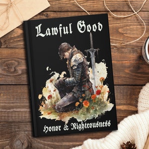 Puede incluir: Un libro negro con las palabras "Lawful Good" en letras blancas. El libro presenta una ilustración de acuarela de un caballero arrodillado con una espada, rodeado de flores. El texto "Honor & Righteousness" está impreso en la parte inferior del libro.