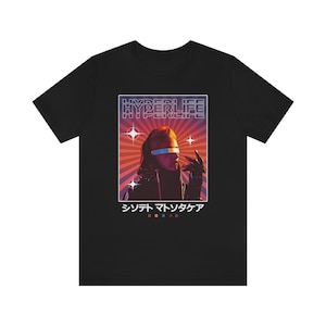 Puede incluir: Camiseta negra con un gráfico de estilo retro de una persona con gafas futuristas y una chaqueta negra. El gráfico incluye el texto "HYPERLIFE" y "シンフォ マツダヤ".