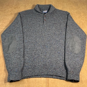 May include: A gray wool sweater with a shawl collar and elbow patches. The sweater has a button-up closure and ribbed cuffs. The fabric has flecks of color throughout.