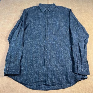 May include: A dark blue shirt with a paisley pattern. The long-sleeved shirt features a classic collar, buttoned cuffs, and a single chest pocket. The fabric has a textured finish. The shirt is suitable for various occasions.
