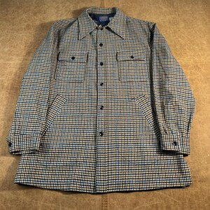 May include: A button-down shirt with a classic plaid pattern in shades of brown, black, and blue. The shirt features two chest pockets, two lower pockets, and black buttons. The collar is a point collar style.