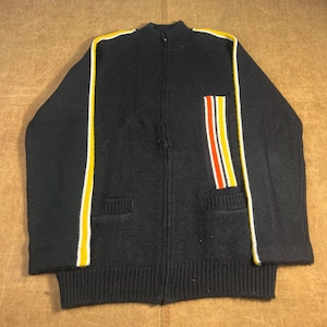 May include: A navy blue zip-up sweater with yellow and white stripes down the sleeves and a vertical stripe design on the chest pocket. The sweater has two front pockets and a ribbed hem and cuffs.