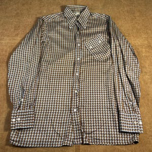May include: A long-sleeved shirt with a brown and white geometric pattern. The shirt features a button-down collar, a chest pocket, and buttoned cuffs. The pattern is a repeating diamond shape.