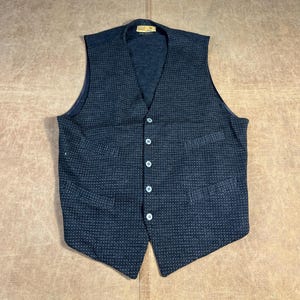 Puede incluir: Un chaleco azul marino oscuro con un sutil estampado de lunares blancos. El chaleco tiene cuello en V, cinco botones blancos y dos bolsillos delanteros. Un estilo clásico, adecuado para combinar.