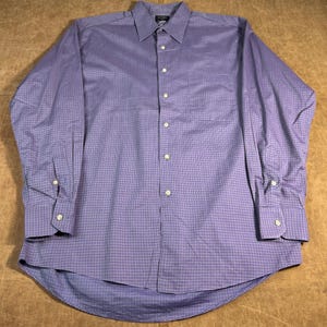 May include: A long-sleeved shirt with a button-down collar in a lavender and red plaid pattern. The shirt features a chest pocket and buttoned cuffs. The fabric is lightweight and suitable for various occasions.