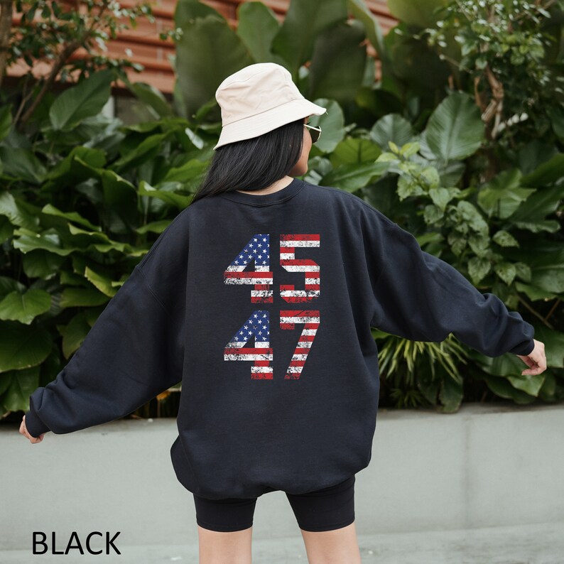 May include: Black sweatshirt with a distressed American flag design featuring the numbers 45 and 47 on the back.