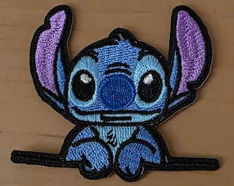 Parche bordado – Simpático alienígena azul asomándose por un borde – se pega y luego se plancha.