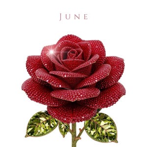 May include: A detailed, sparkling red rose sculpture with green leaves and stem. The rose petals are covered in small, glittering red gems. The word "JUNE" is written in a burgundy color at the top.