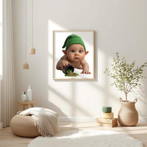 May include: A framed print showing a baby in a green leprechaun hat and pointed ears, crawling and spilling a pot of gold coins. The print is displayed on a white wall. The image has a whimsical theme.
