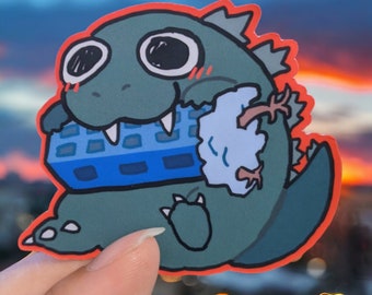 May include: A green cartoon monster with a blue and white keyboard in its mouth and a white cloud in its hand. The monster has a red outline and is holding the keyboard and cloud in its mouth and hand.