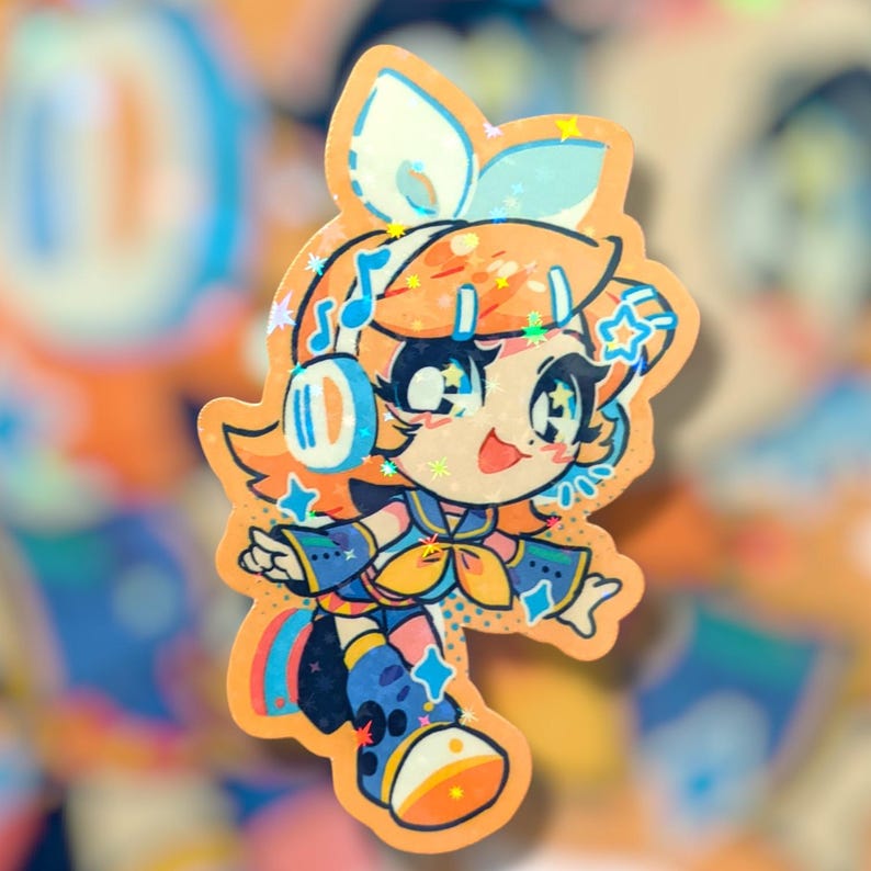 May include: A colorful sticker featuring a cartoon character with orange hair, blue headphones, and star accents. The character is wearing a blue and yellow outfit with musical notes and star details. The sticker has a holographic, glittery finish.