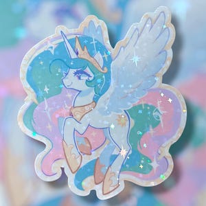 May include: A sticker featuring a cartoon illustration of a winged unicorn with a crown. The unicorn has a light blue body, a flowing mane, and a golden crown. The sticker has a holographic, glittery effect with pastel colors.