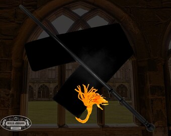 May include: A black wand with a black tassel and a gold dragon design. The wand is lying on a black velvet pouch.